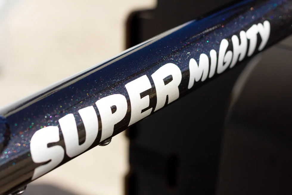 Schriftzug Super Mighty auf glitzerndem Alu-Rahmen